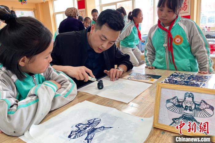 美术老师刘飞在课后服务时段与学生共同动手制作手工艺品。　李佩珊 摄